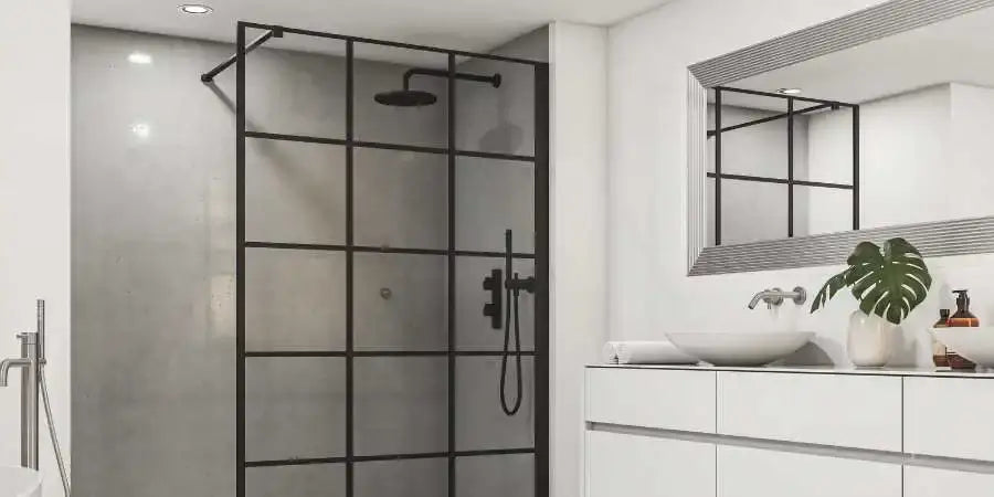 Mampara de ducha fija estilo taller con perfilería negra cuadriculada junto al mueble de lavabo